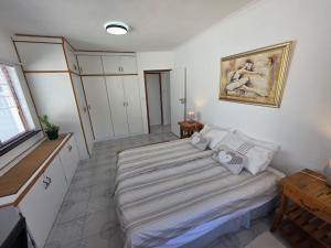a bedroom with a bed and a painting on the wall at Alvera in Strand