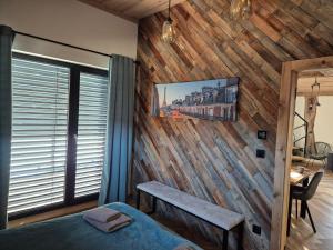 a bedroom with a wooden wall with a bench at Luxusny apartman z tarasmi - Vera in Telgárt