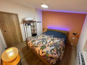 a bedroom with a bed with a colorful comforter at Le Chalet des 5 avec piscine vue sur les montagnes et en lisière de forêt in Lutzelhouse +37 photos