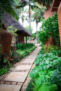 ポロクワネにあるGeoreen Guest Houseの建物の隣の庭にある石畳の歩道