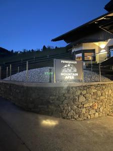 um sinal numa parede de pedra em frente a um edifício em Mountain Apex em Dölsach