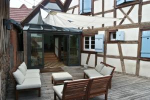 an outdoor patio with two chairs and a table at Le temps des cigognes in Barr