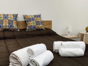 uma cama com toalhas e almofadas em Garden Relax Suites em Ispica mais 28 fotografias