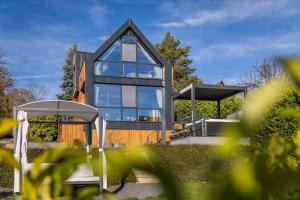 a house with glass windows and a gazebo at LoveNest Hungary in Győrújbarát