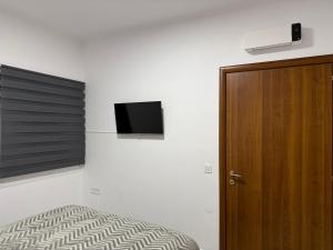 コウノピィディアーナにあるOneiro Apartmentのベッドと壁にテレビが掛かった寝室