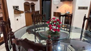 ein Glastisch mit einem Blumenstrauß darauf in der Unterkunft Luxstay kochi in Kochi