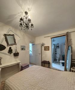 a bedroom with a bed and a chandelier at Le Domaine de Cécile by Alto Service in Perpignan