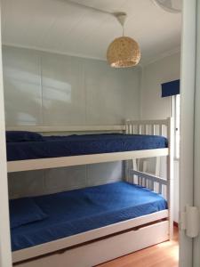 two bunk beds in a room with blue sheets at Tu lugar de relax a 2 cuadras de la playa Se reserva con seña in Guazuvira
