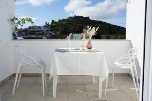 Una mesa blanca y sillas en un balcón con vista. en Principado de Aracena I, en Aracena 20 fotos más