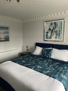 a bedroom with a bed with a blue and white blanket at The Pantiles in Bolsover