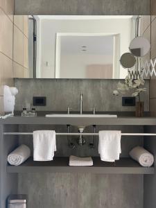 a bathroom with a sink and a mirror and towels at Membrillar suites de Montaña in Valle Grande +26 photos