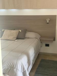 a bed with white sheets and pillows in a room at Membrillar suites de Montaña in Valle Grande