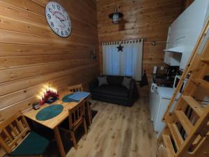 una stanza con un tavolo e un orologio sul muro di Lapland Forest Lodge a Rovaniemi