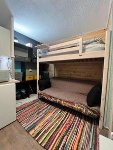 a bedroom with two bunk beds and a rug at Studio centre-ville in Cluses
