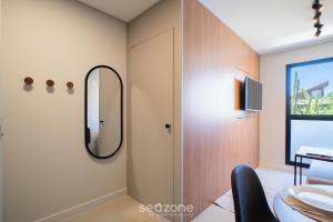 een badkamer met een spiegel en een wastafel bij Studios Modernos a 2km da Praia do Rosa - RSOs in Praia do Rosa