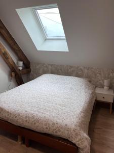 Un dormitorio con una cama y una claraboya. en La p'tite maison, en Courgains