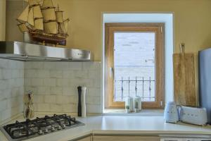 eine Küche mit einem Herd und einem Fenster in der Unterkunft Casa Vicolo TerminIO in Fermo