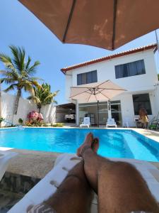 a man laying on a bed next to a swimming pool at Casa de playa Iberico in Caleta Grau