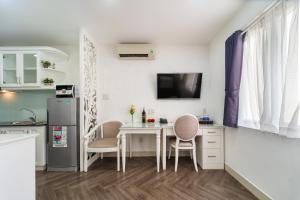 ホーチミン・シティにあるSabina Residence - HCMのテーブルと椅子と冷蔵庫のあるキッチン