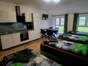 a room with two beds and a kitchen with a table at Speedy's Gästehaus in Reimerath