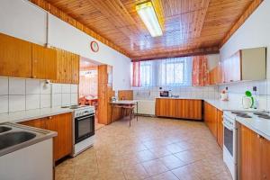 a large kitchen with wooden cabinets and appliances at Horská CHATA U ŠPIČÁKU in Josefuv dul