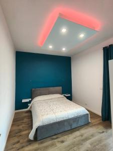 une chambre avec un grand lit avec un mur bleu dans l'établissement Suite il Sogno, à Francavilla al Mare