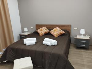 uma cama grande com duas toalhas em cima em Garden Relax Suites em Ispica