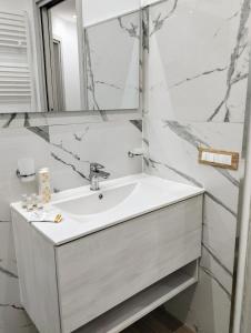 um banheiro branco com uma pia e um espelho em Garden Relax Suites em Ispica