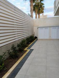 uma entrada de automóveis com um muro de contenção e uma garagem em Garden Relax Suites em Ispica