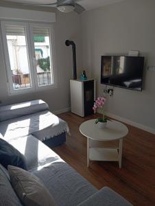 a living room with a couch and a tv and a table at Casa de la Fortuna in Huétor Vega