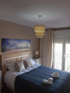 a bedroom with a blue bed with two towels on it at Casa de la Fortuna in Huétor Vega