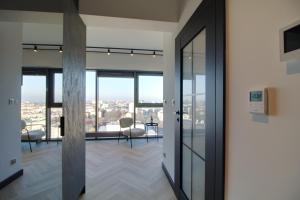 an office with glass doors and a view of a city at Apartament Loft Olszynki Park in Rzeszów
