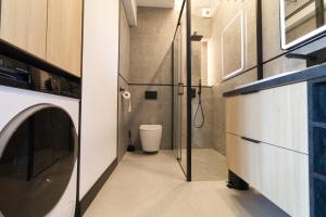 a bathroom with a toilet and a washer and dryer at Apartament Loft Olszynki Park in Rzeszów +19 photos
