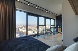 a bedroom with a bed and a view of the city at Apartament Loft Olszynki Park in Rzeszów