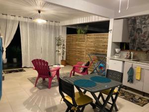 uma sala de estar com mesa e cadeiras e uma cozinha em Appartement 2 personnes em Rivière-Salée