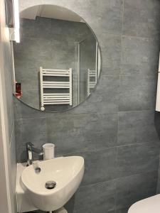 un bagno con un lavandino bianco e uno specchio di Dinard: studio à 100 m de la plage de L'Ecluse a Dinard Altre 9 foto