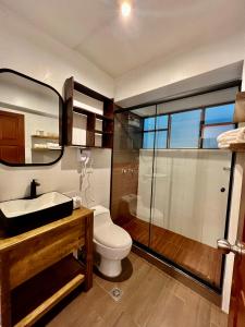 a bathroom with a toilet and a sink and a shower at Casa Encuentro San Blas in Cusco +66 photos