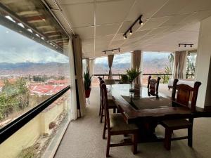 a dining room with a table and views of the mountains at Casa Encuentro San Blas in Cusco
