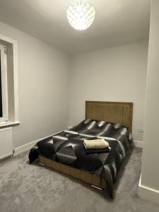 una camera da letto con un letto grande in una stanza bianca di Simple & Peaceful Space a Colne