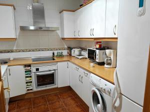 een keuken met witte kasten en een wasmachine en droger bij VIRGEN de ALFILERITOS in Toledo
