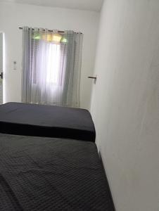 En eller flere senge i et værelse på Quintal da Ane Caraguatatuba