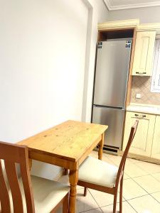 Una cocina con una mesa de madera y un refrigerador. en Casa Verde Blu, en Perivólion 10 fotos más