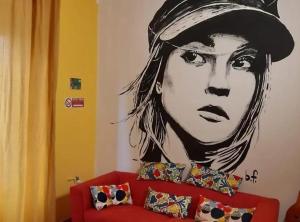 Un dipinto di una donna con un cappello su un muro di pisa train station hostel a Pisa