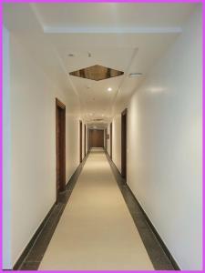 um longo corredor com paredes brancas e um tecto em SEA VIEW from rooftop AP INN Hotel - Restaurant And Lift - Air-Conditioned Rooms with Balconies - A sea view Luxuary Hotel em Puri