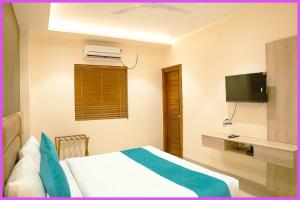 um quarto de hotel com uma cama e uma televisão em SEA VIEW from rooftop AP INN Hotel - Restaurant And Lift - Air-Conditioned Rooms with Balconies - A sea view Luxuary Hotel em Puri