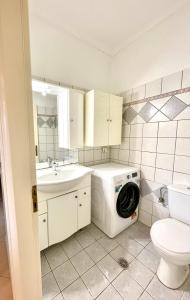 Un baño con lavadora y lavabo. en Casa Verde Blu, en Perivólion