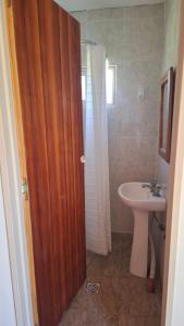 un bagno con lavandino, servizi igienici e porta in legno di El Campito 2 a Necochea