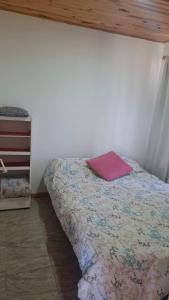 una camera da letto con un letto con un cuscino rosa di El Campito 2 a Necochea