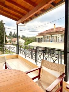 Un balcón con una mesa y sillas de madera y un edificio. en Casa Verde Blu, en Perivólion