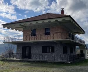 a house with a balcony on top of it at Village House by nature in Karkaloú